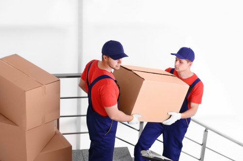 Careful unloading of furniture and boxes into a new home in Bow