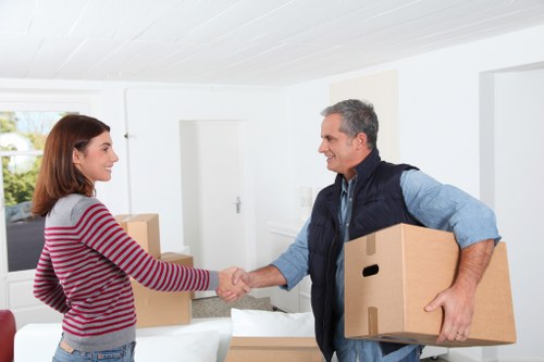 Movers handling office furniture dismantling during a Bow relocation